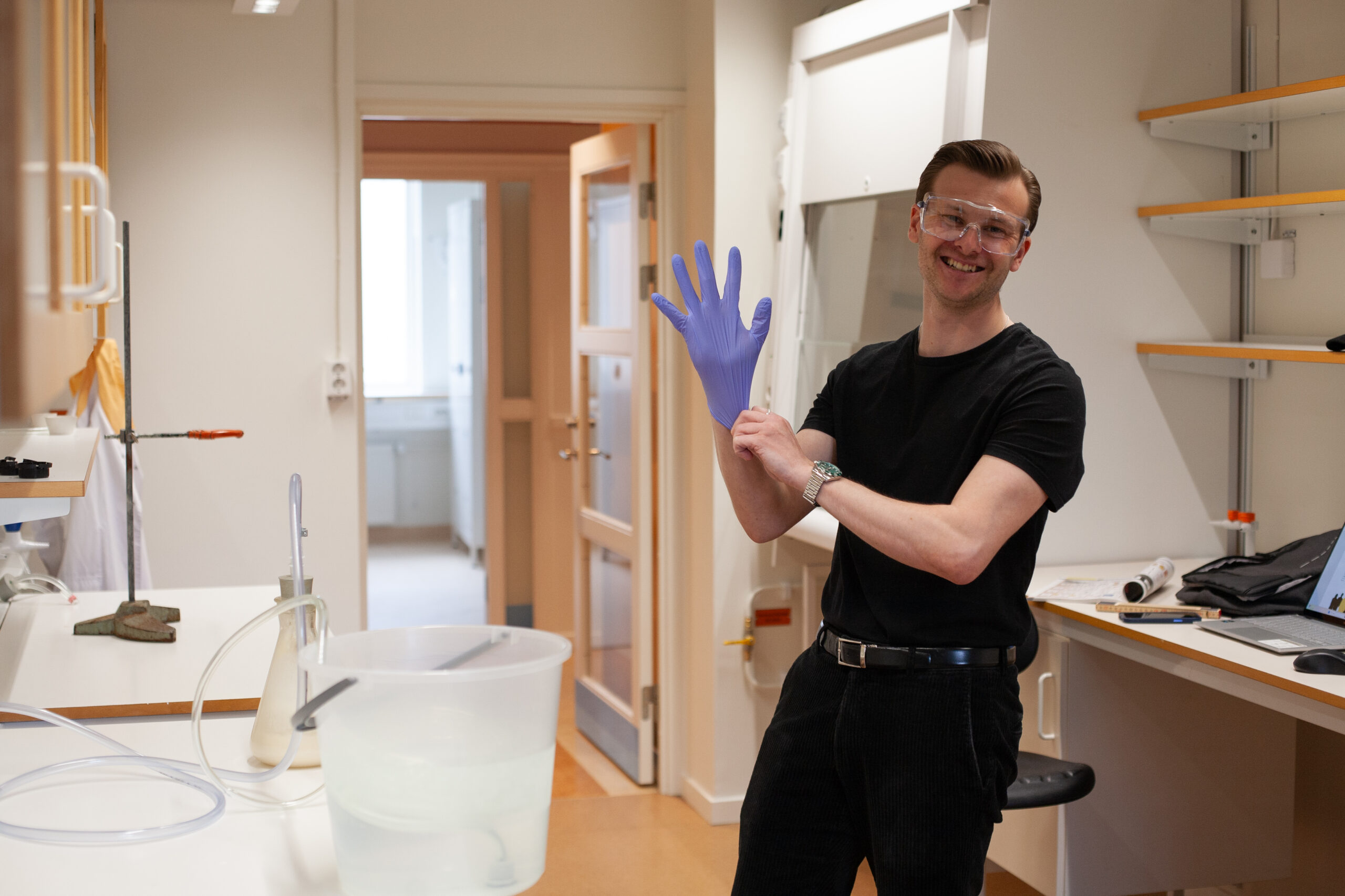 Hugo Boccara ler mot kameran och tar på sig en plasthandske