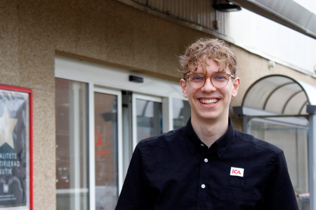 Oscar Dolk framför butiken där han arbetar som chef.